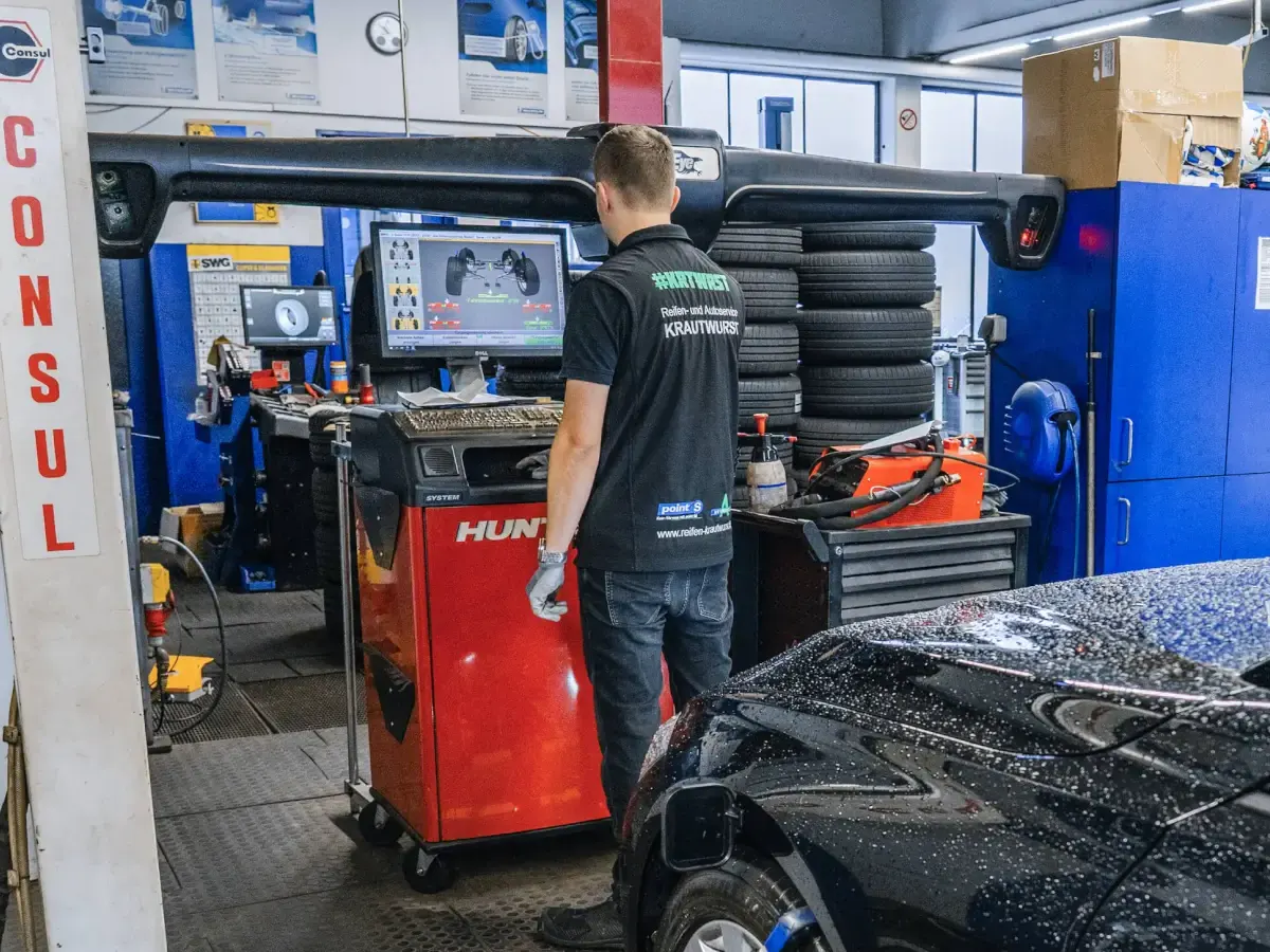 Mitarbeiter am roten Hunter-Messpult, darüber der Kamerabalken, vorn rechts ein schwarzes Auto auf dem Messstand