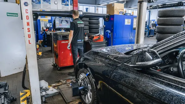 Schwarzes Auto auf der Hebebühne am Achsmessstand