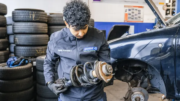 Mechanic holding a removed strut in his hands